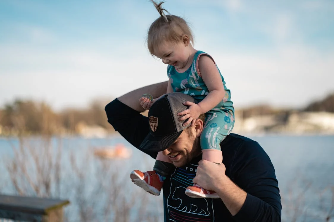 A father carrying a baby on his shoulders