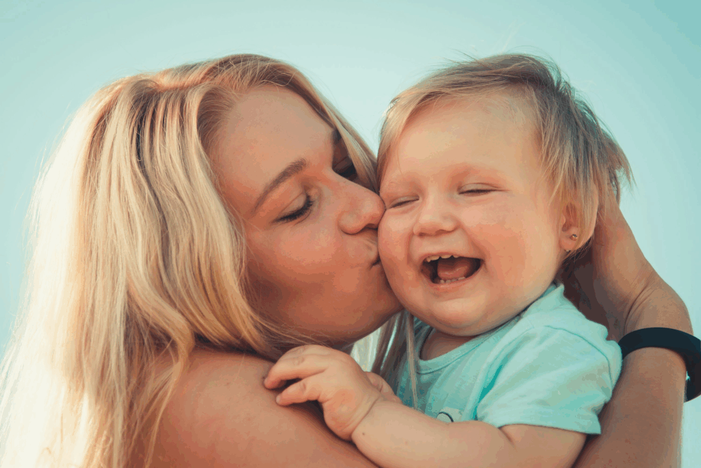 A woman kissing a child on the cheek