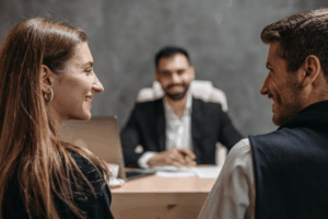 Smiling couple discussing marriage planning and prenuptial agreements with their attorney