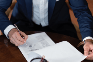 Close-up of hands signing paperwork with guidance from a Houston divorce law firm.