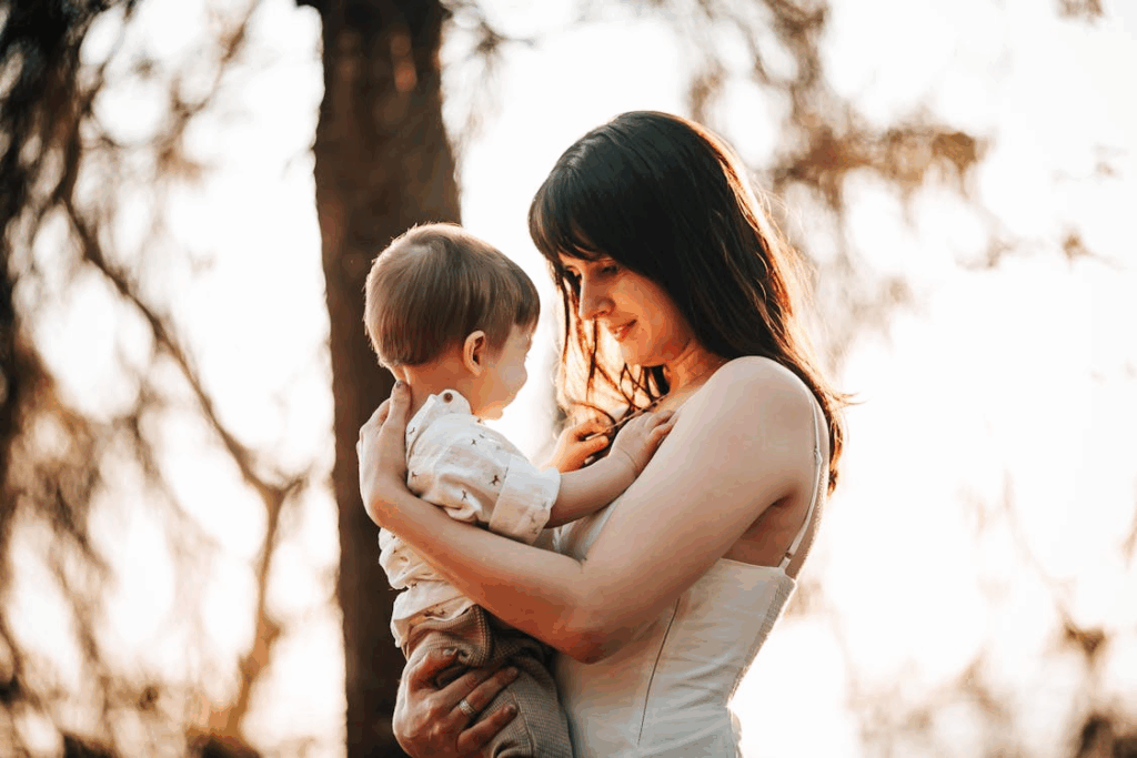 A mother holding her baby in a forest