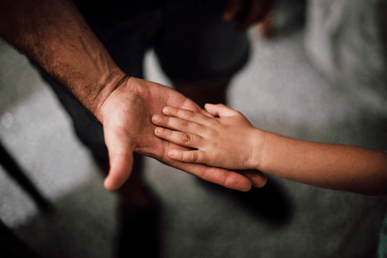 A child’s hand on his father’s