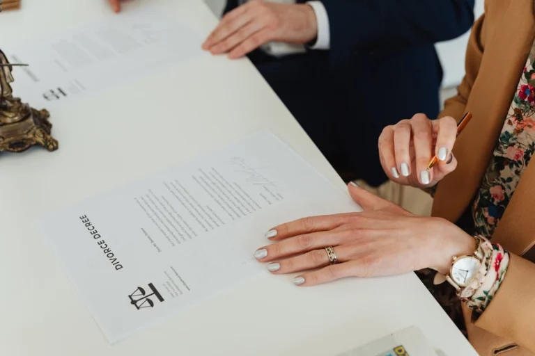 A Man and a woman signing legal documents with guidance from a divorce attorney in Ingram Hills, Texas.