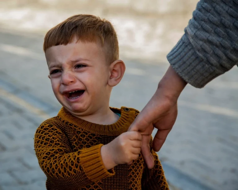 A child cries while saying goodbye to a parent during a custody dispute.