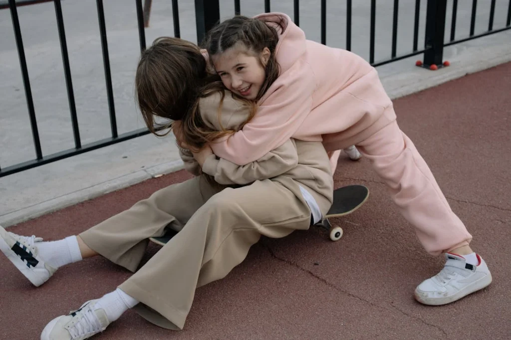 A happy child hugs their sibling.