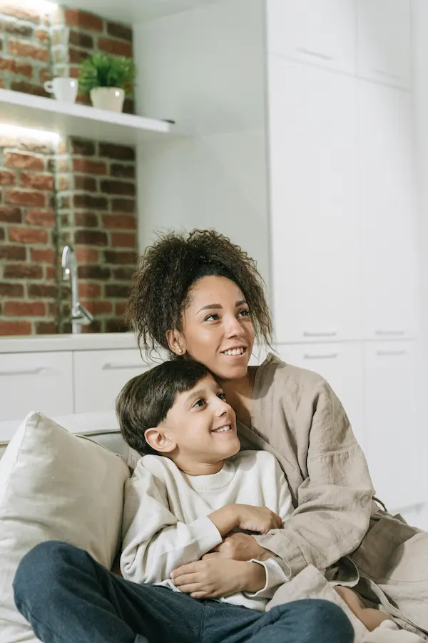 Mother sitting with her son watching TV, symbolizing CPS and custody cases handled by family lawyers in Old Town