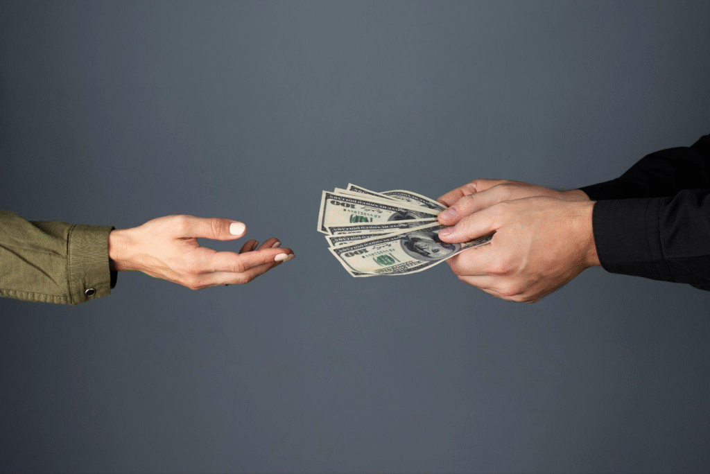 A person giving money to another person