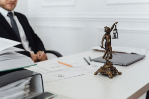  a lawyer sitting on his chair in his office with a lady justice statue on his desk