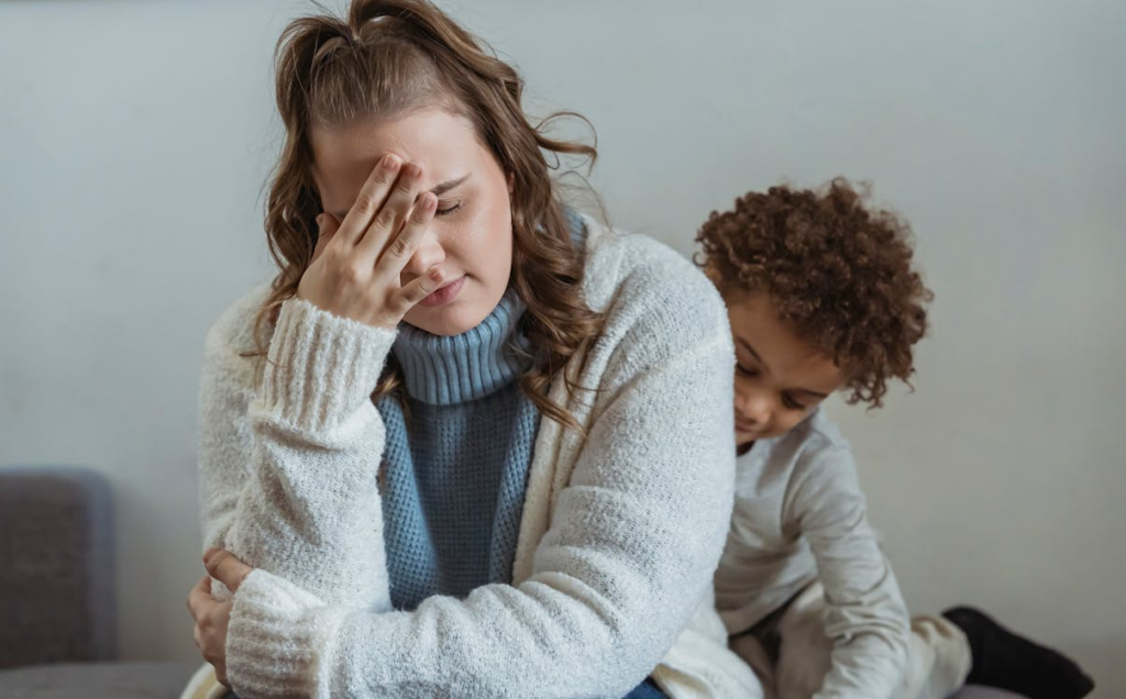 close-up of a boy trying to comfort his upset mother, holding her hand to her forehead