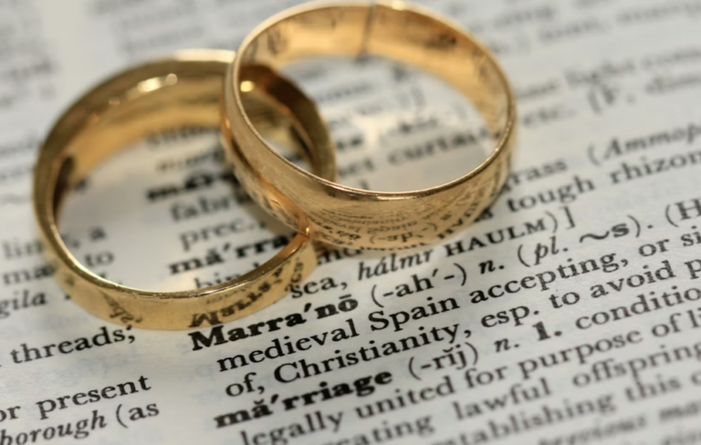 This image shows two gold rings lying on a document.