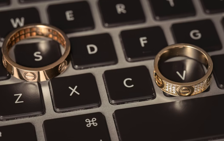 This image shows two wedding rings sitting on top of a laptop keyboard