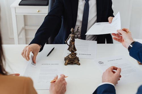 Couple sitting with an uncontested divorce lawyer as they review and sign divorce papers.
