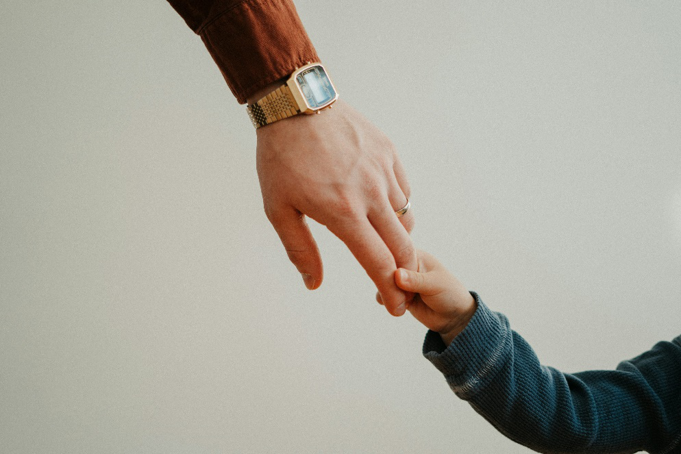 Father holding his child’s hand.