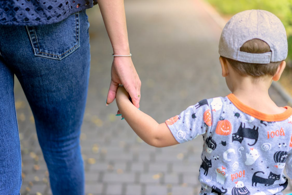 A person holding the hands of a child