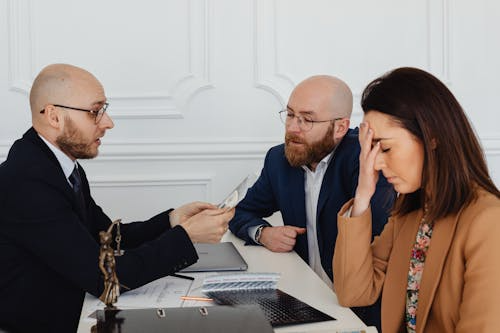 A couple sitting with a mediator during a stressful divorce discussion in an office