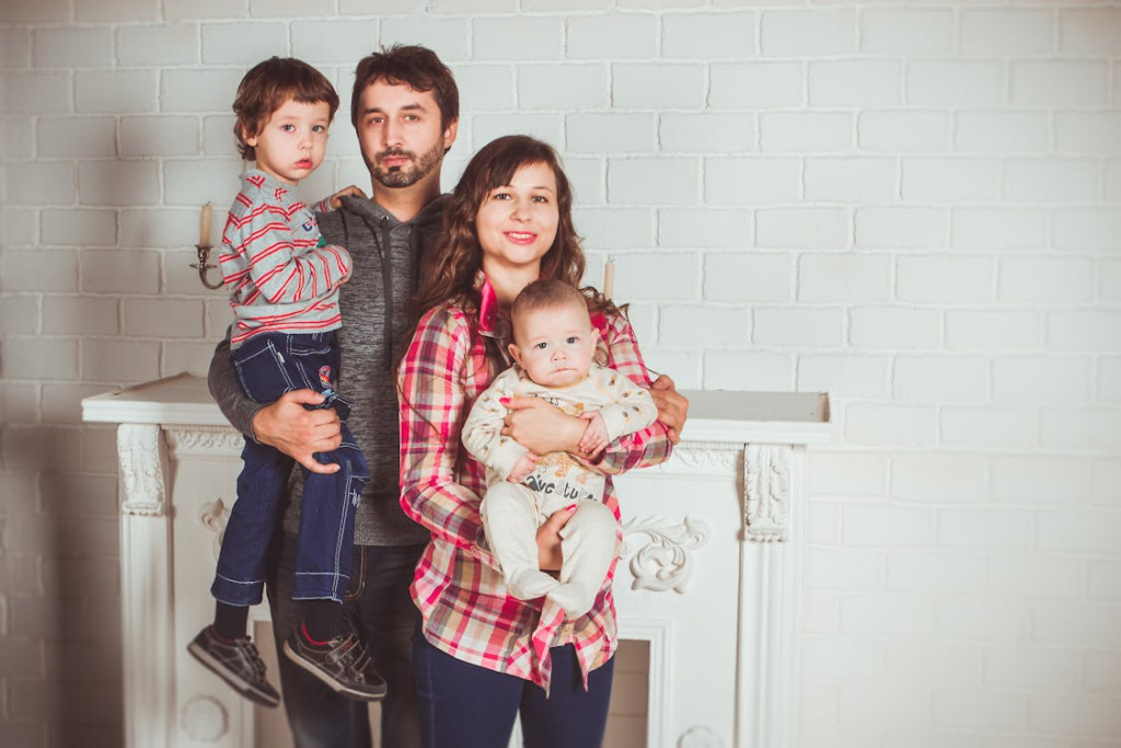 A family standing together near a fireplace