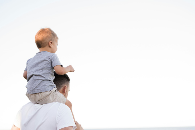 Father carrying his child on his shoulders while spending time outdoors