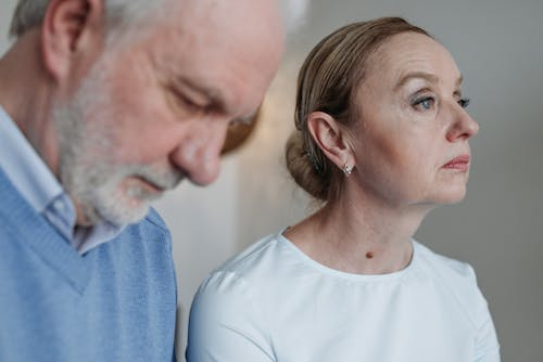 Elderly couple sitting thoughtfully during divorce discussions