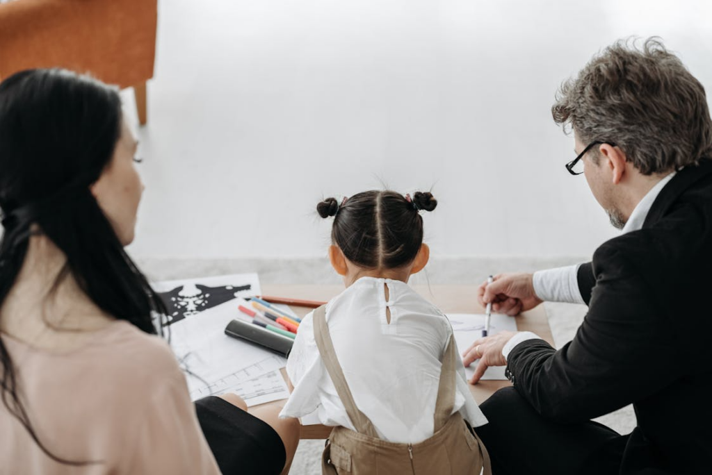 Child sitting with parents during a custody-related discussion about family court arrangements.