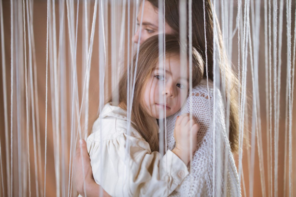 a mother embracing her daughter behind a curtain