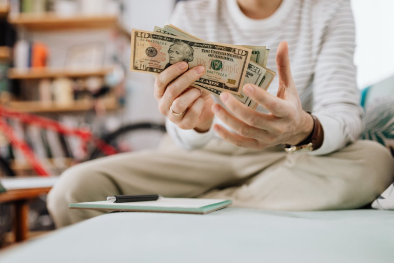 A person sitting on the couch and holding money