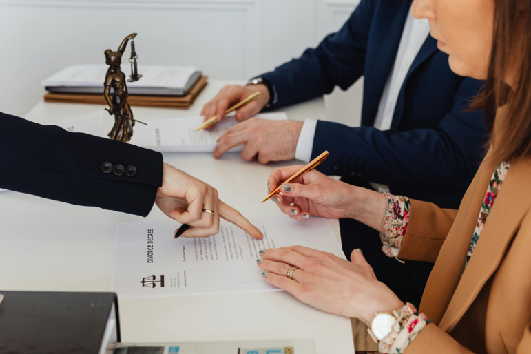 Couple reviewing and signing uncontested divorce paperwork with an attorney in Houston