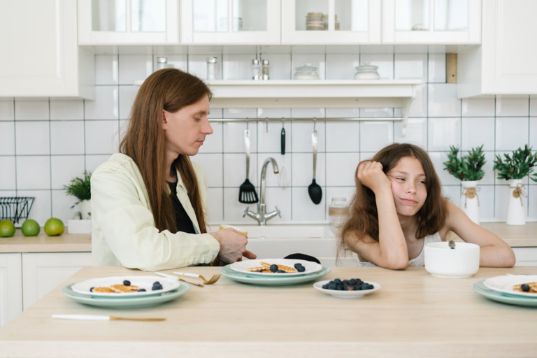 A parent and child sitting on the kitchen countertop with food