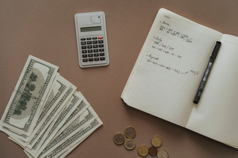 a calculator surrounded by bills and coins