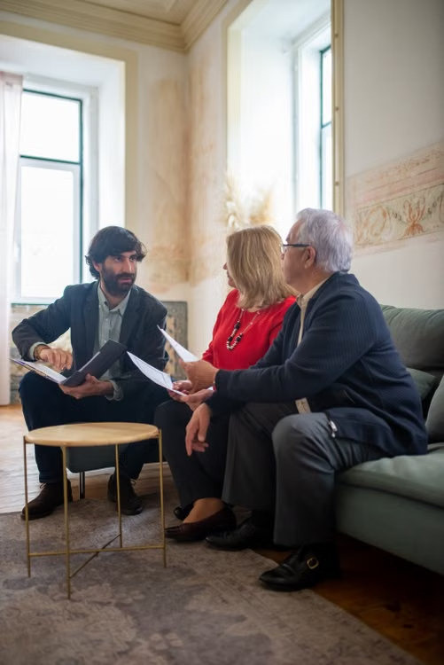 a couple discussing finances with an advisor in a living room
