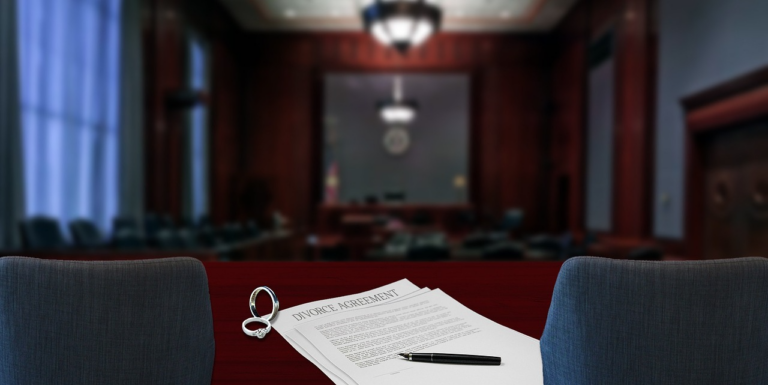 a courtroom with divorce papers and rings placed on a desk