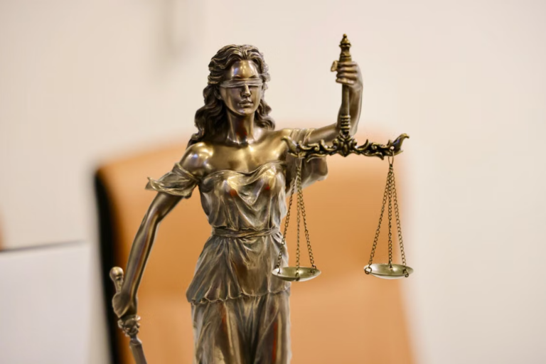 This image shows a close-up of a Lady Justice statue holding scales.