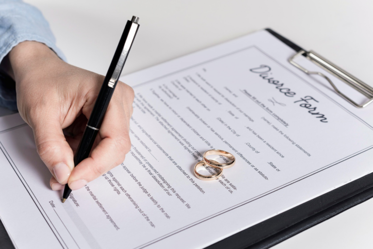 This image shows a close-up of a hand signing a document with a fountain pen.