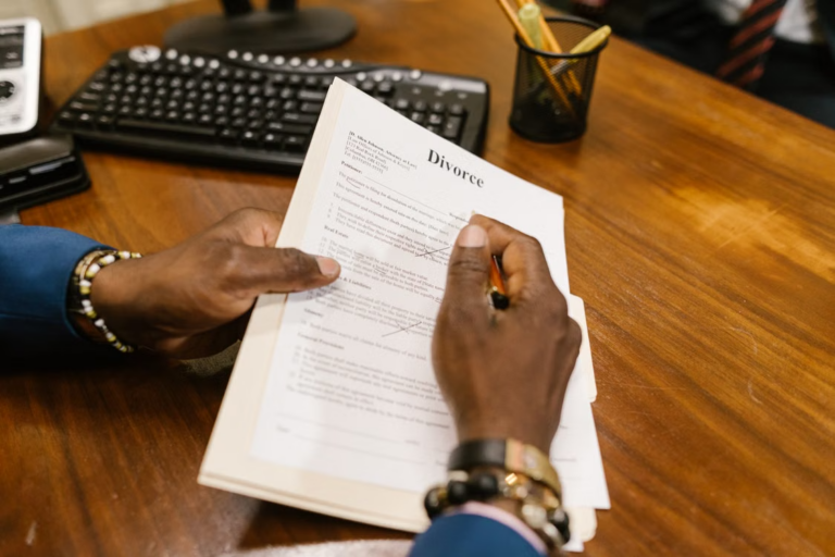Person reviewing and signing divorce papers during a high-asset divorce consultation in Bunker Hill Village.