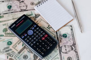 a calculator beside a notepad