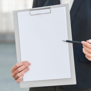A person holding a pen and a piece of paper