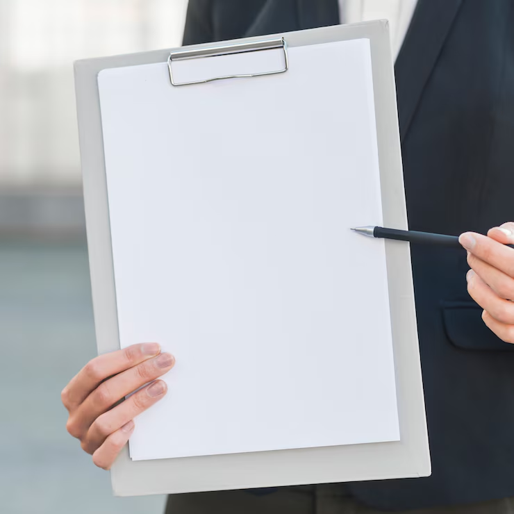 A person holding a pen and a piece of paper