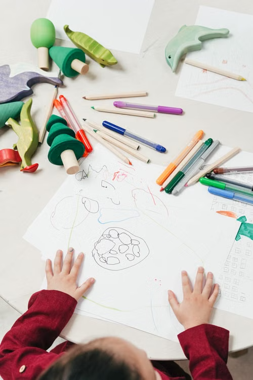 a child drawing at a table