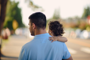 a parent standing with their child