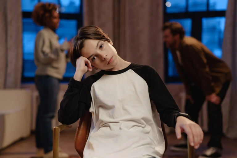 Young boy sitting while his parents discuss family matters in the background