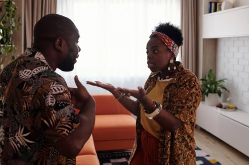 Couple arguing in their living room during a disagreement about family matters