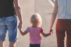 a child holding its parents' hands
