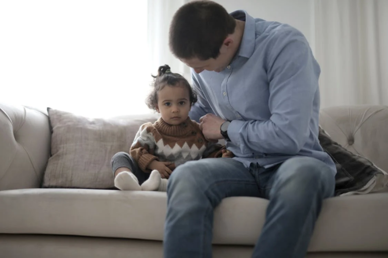 An image of a man sitting beside his child