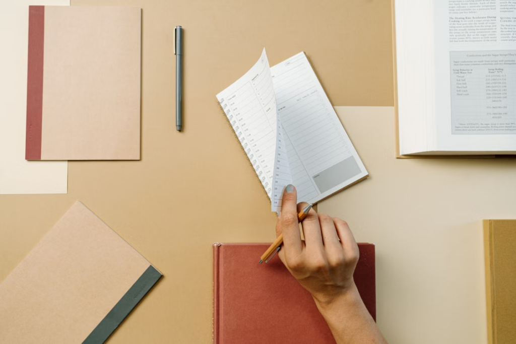 A hand flipping through the pages of an office calendar