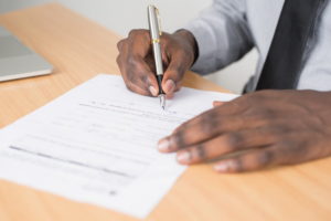 Client signing documents with guidance from a Houston divorce law firm mediator.