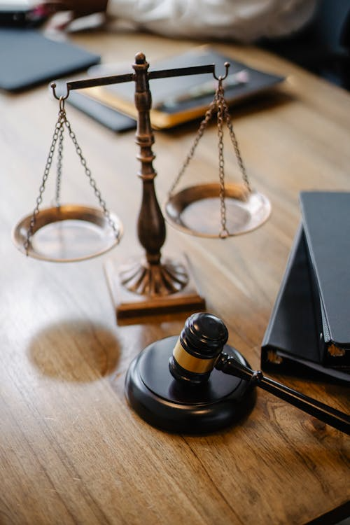 close-up of a judge’s desk with a balance scale and a gavel