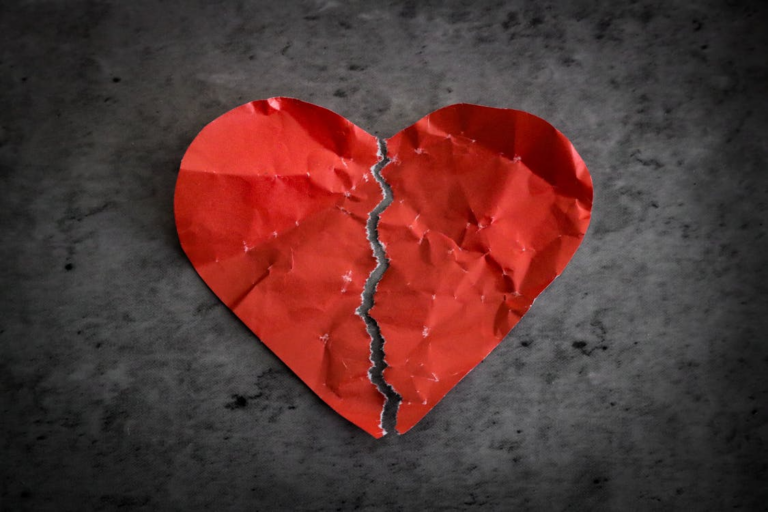 A ripped and crumbled red paper heart