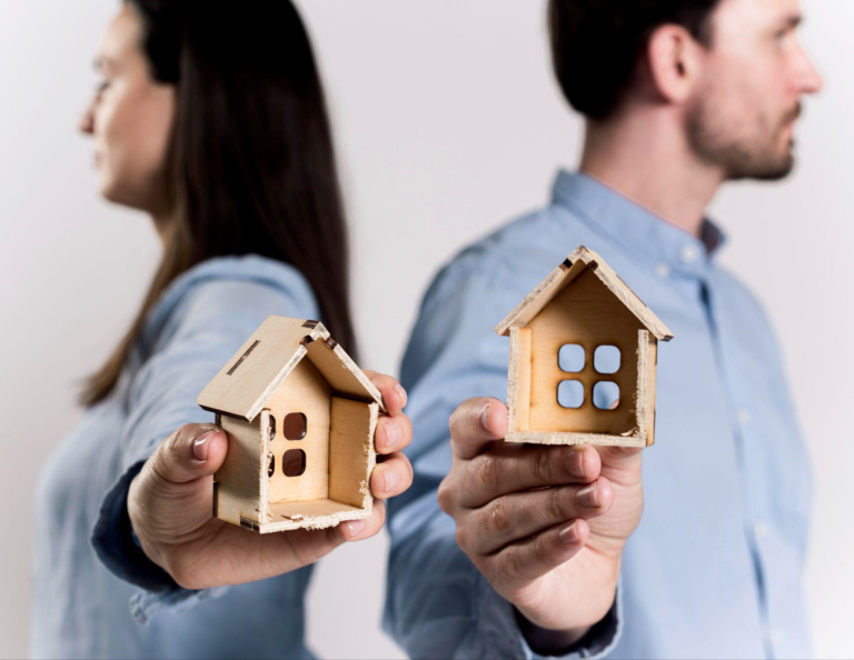 Divorcing couple holding separate model houses during the divorce process