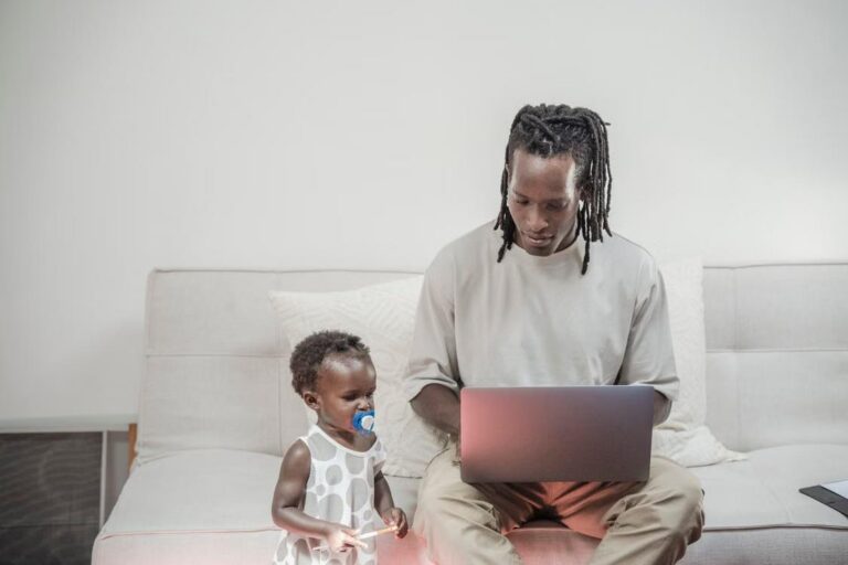 A man working while taking care of his child